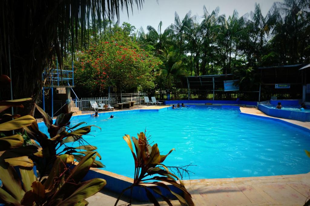 una gran piscina azul con gente en ella en Villa Hermosa de Tambopata Casa Hospedaje & Hostel, en Puerto Maldonado