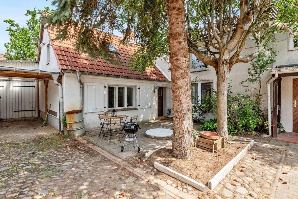 una casa con una mesa y un árbol en el patio en „Landidylle Niederlausitz“ – Gemütliches Feriendomizil zwischen Natur und Kultur, en Heideblick