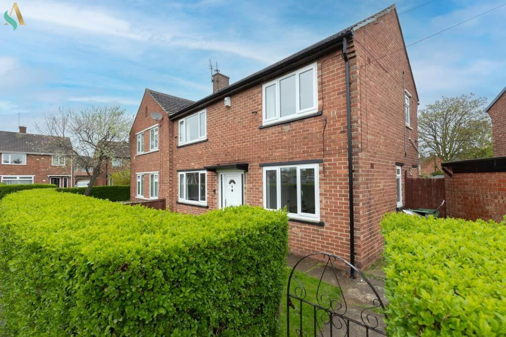 a brick house with a hedge in front of it at Gilside Lodge in Stockton-on-Tees