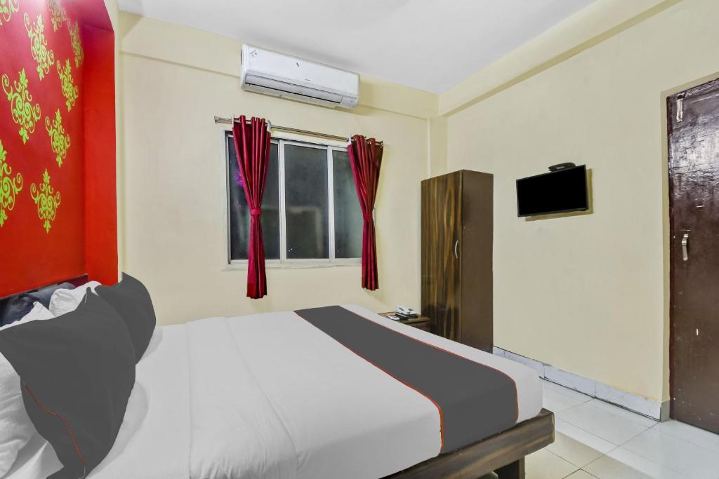 a bedroom with a white bed and a television at Collection O Hotel Lemon Arrow Inn in Howrah