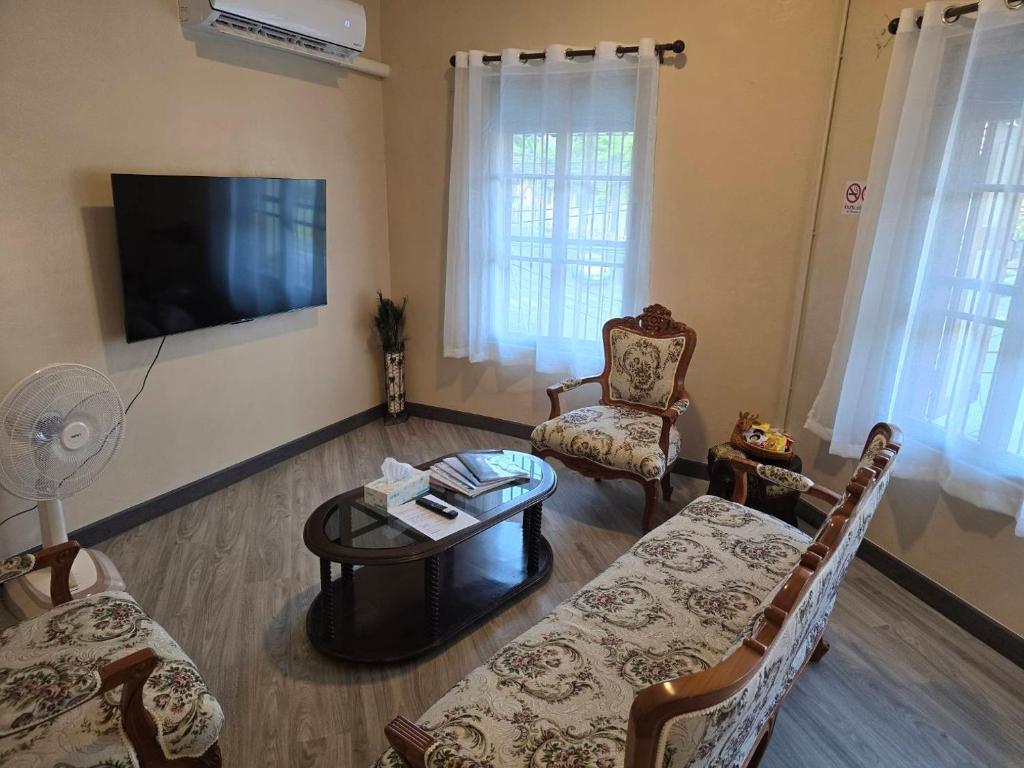a living room with a couch and a table and a tv at Victory place 2 (Golden Mount) in Bangkok