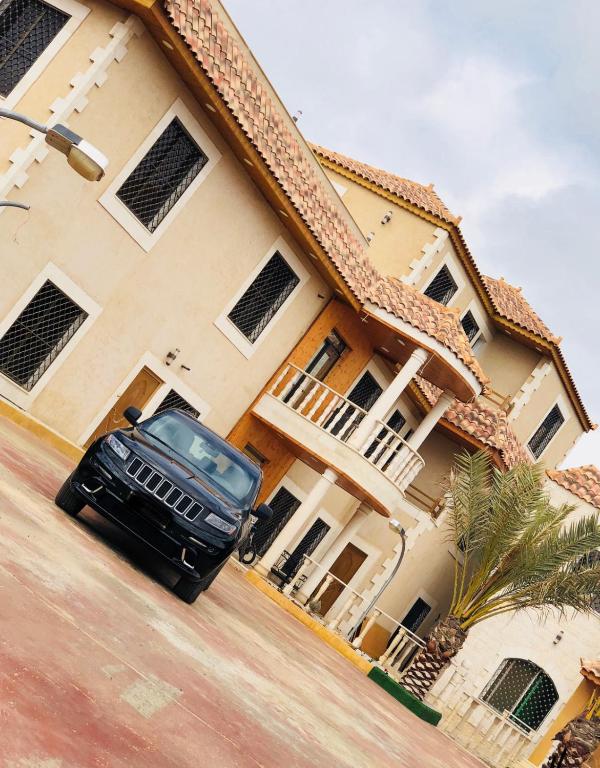 una macchina nera parcheggiata di fronte a una casa di مزرعة كراون a Umm el ‘Amad