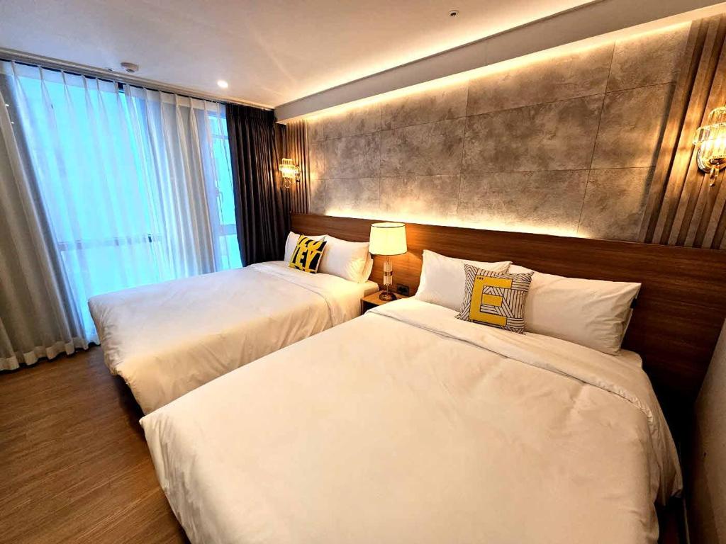 ein Hotelzimmer mit 2 Betten und einem Fenster in der Unterkunft Raviens라비앙즈 in Busan