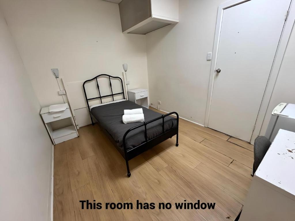 Studio B - Wright Lodge في أديلايد: غرفة بسرير وغرفة بدون نافذة