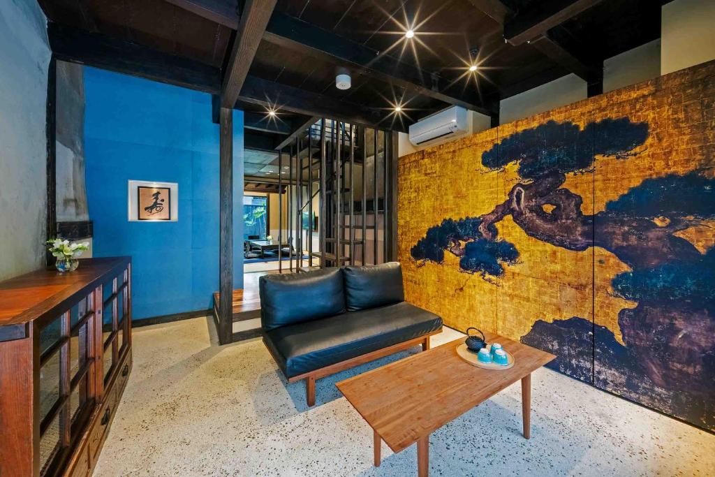 uma sala de estar com um sofá e uma mesa em Asagi an Machiya House em Quioto