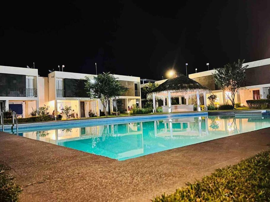 una piscina frente a un edificio por la noche en La casa frente a la alberca en Tlayecac
