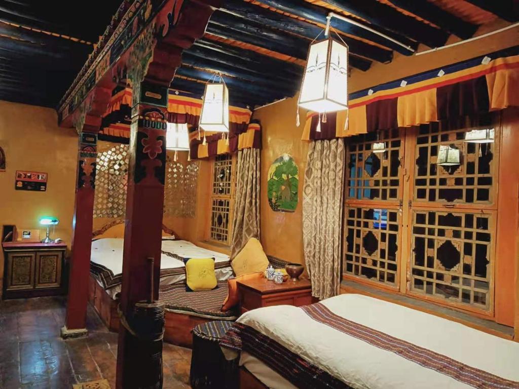 a bedroom with two beds in a room with windows at Shambhala Palace Hotel in Lhasa