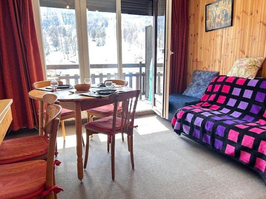 une salle à manger avec une table et un canapé dans l'établissement Appartement 4 couchages, skis aux pieds, proche commerces à Risoul - FR-1-330-580, à Risoul