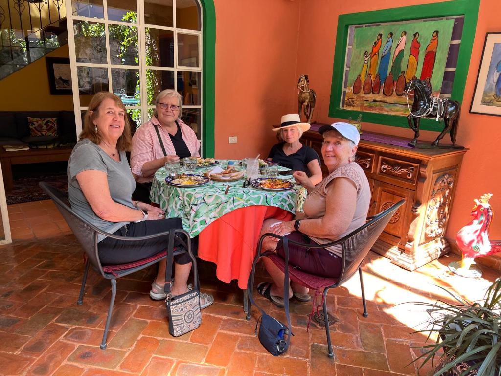 un grupo de personas sentadas alrededor de una mesa en Casa Camellia, en San Miguel de Allende