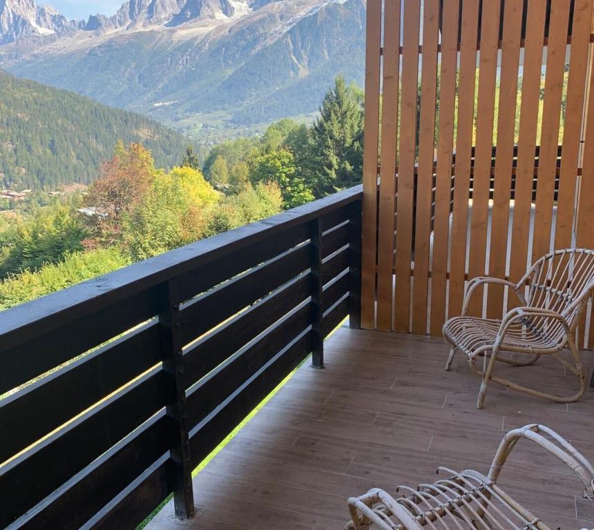 d'un balcon avec des chaises et une vue sur les montagnes. dans l'établissement Aiguilles furnished flat, aux Houches