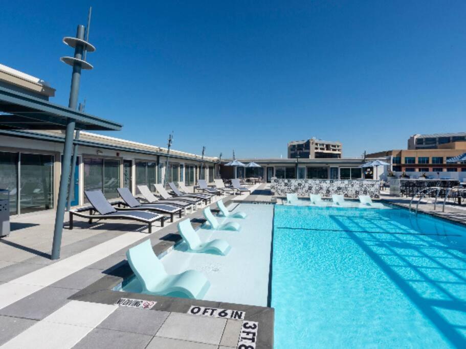 a swimming pool with lounge chairs next to a building at Elite Retreat in Addison Circle in Addison