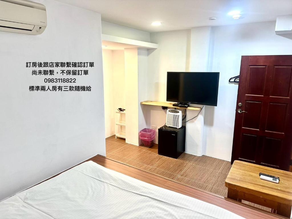 a room with a tv and a bed and a door at Nanwan254 Homestay in Nanwan
