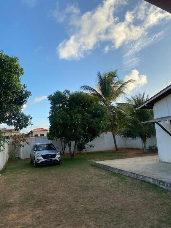 um carro estacionado num quintal ao lado de uma casa em Residencial Sauaçhuy em Ipioca