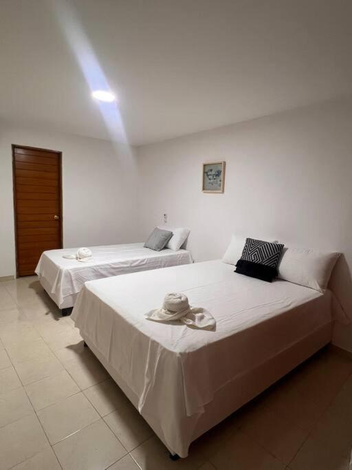 - 2 lits dans une chambre blanche avec un canapé dans l'établissement Apartaestudio campestre, à Valledupar