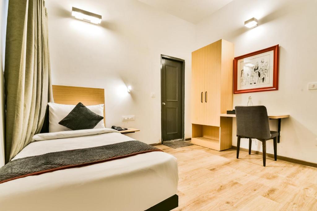 a hotel room with a bed and a desk at Townhouse 182 Menka in Patna