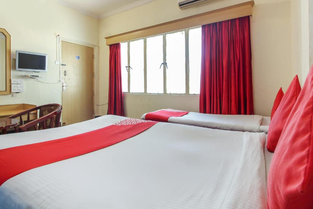 1 dormitorio con 1 cama grande y cortinas rojas en OYO Luxury Villas Near Begumpet Airport en Ameerpet