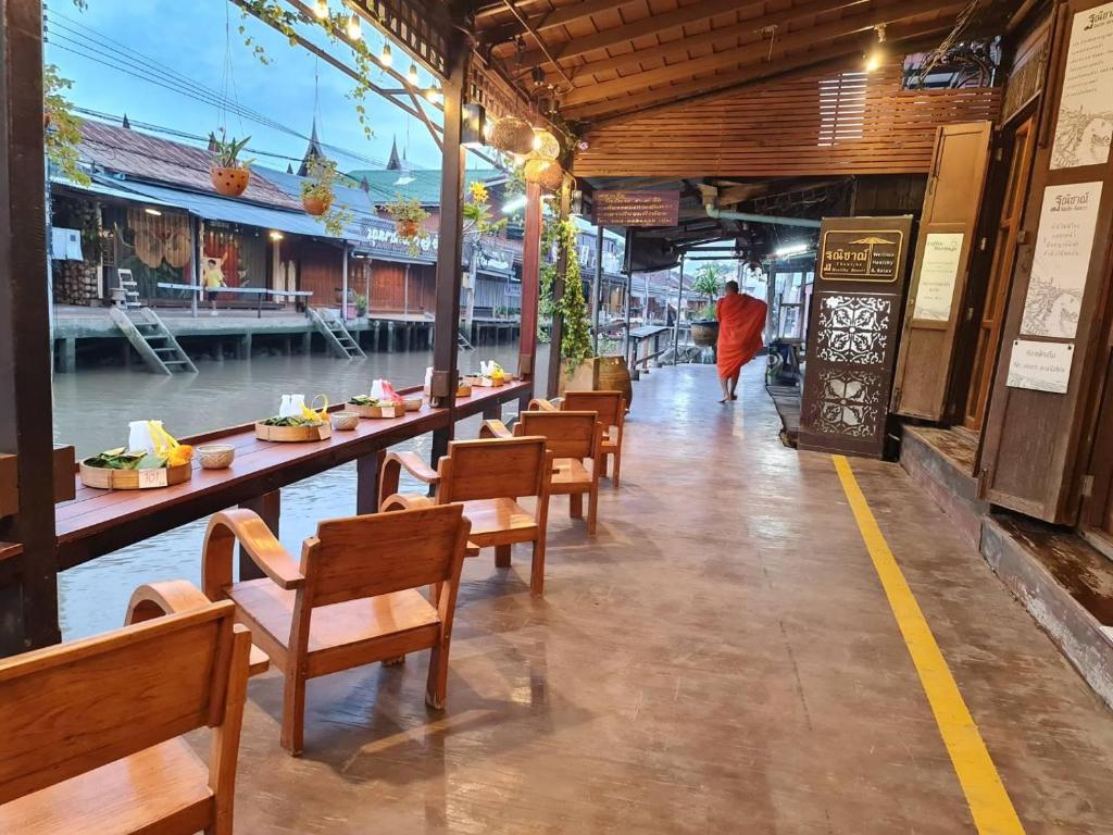 a row of tables and chairs in a restaurant at Thanicha Resort Amphawa in Amphawa