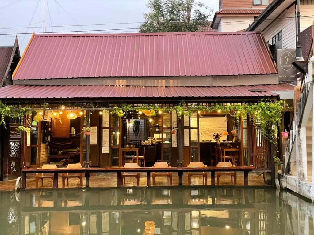 安帕瓦的住宿－Thanicha Resort Amphawa，房子旁边的水面上的餐厅