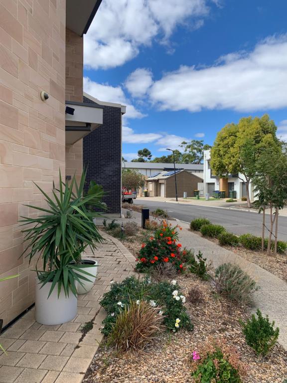 un marciapiede con piante e fiori accanto a un edificio di Stellar Suite a Woodville South