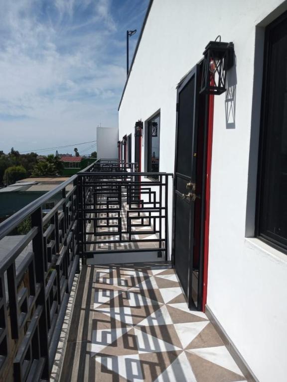 a balcony with black doors and a checkered floor at Sunrise Apartments in Rosarito