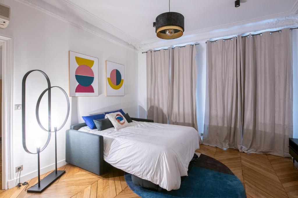 una camera con un letto e una grande finestra di Le Reno By Hotel Home - Appartement 1 Chambre - 4 Personnes - Vue Sur Rue a Parigi