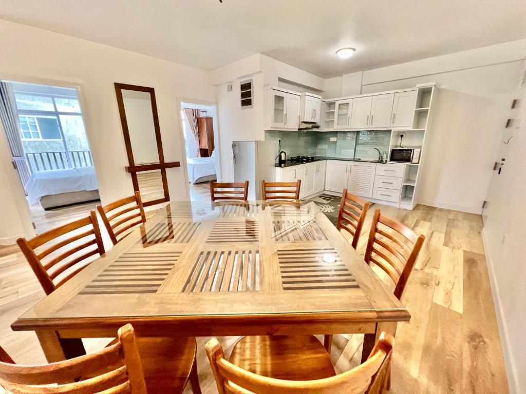 een keuken en eetkamer met een houten tafel en stoelen bij Lake View Residencies in Nuwara Eliya