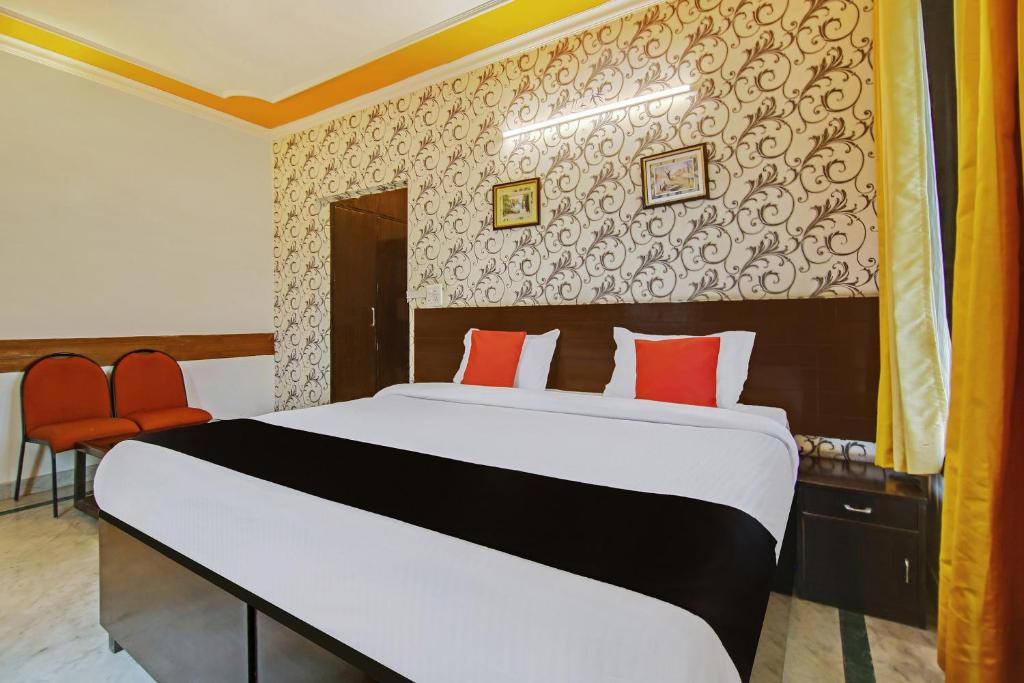 a bedroom with a large bed with red pillows at Super Capital O Tipsyy 006 Near Aravali Biodiversity Park in Gurgaon