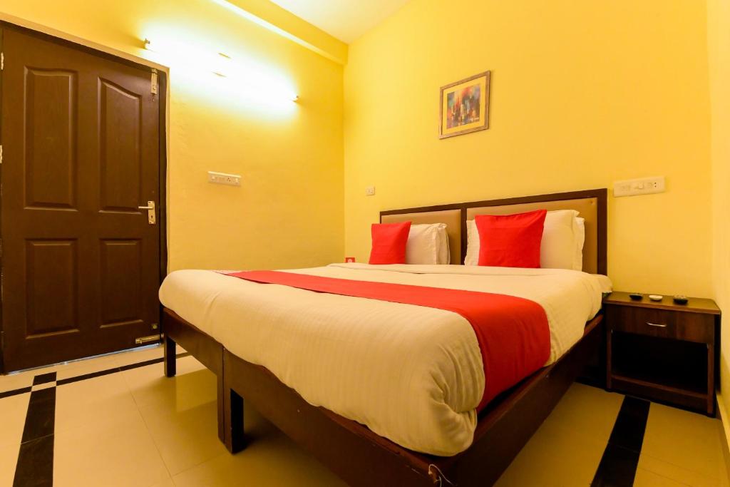 a bedroom with a large bed with red pillows at Super OYO Flagship Hotel Diamond In in Kakkanad