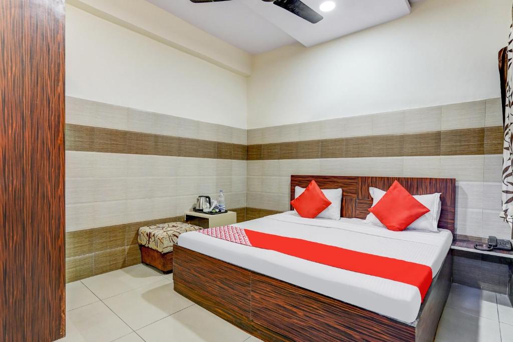 sypialnia z dużym łóżkiem z czerwonymi poduszkami w obiekcie Super OYO Hotel 7 Sky w mieście Ludhiana