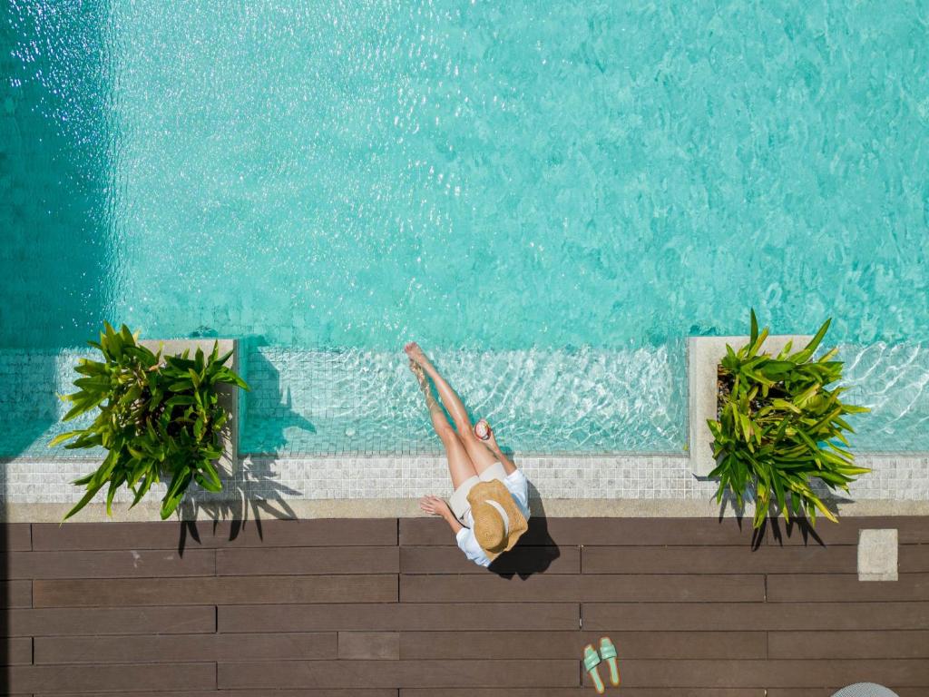 a woman is diving into a swimming pool at Patong Bay Residence in Patong Beach