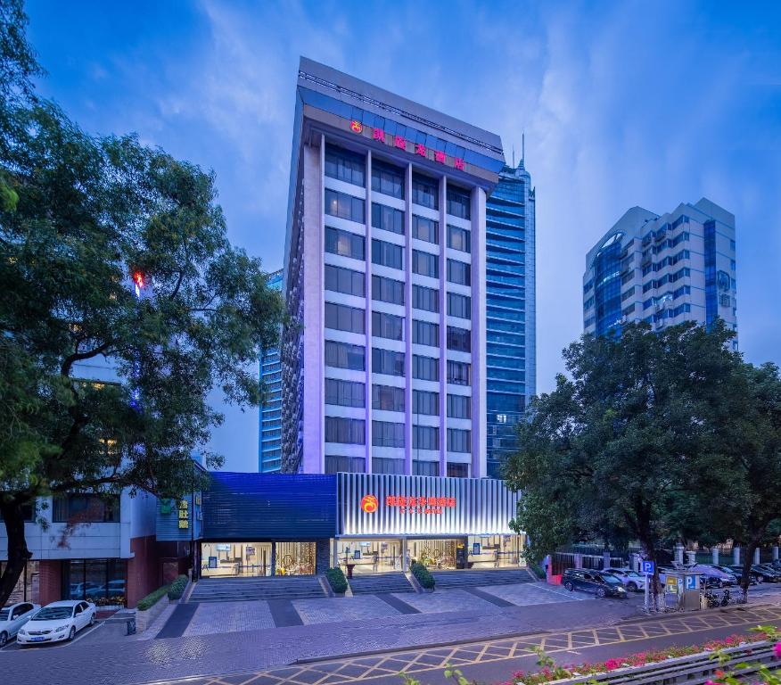un edificio alto en una ciudad con edificios en Kaiserdom Hotel - Visit Canton Tower & Beijing Road , Shuttle Bus to CantonFair Complex & Breakfast during Canton Fair period, en Guangzhou