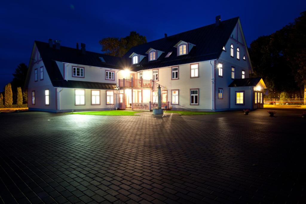 a large white house with lights on at night at Hotell Räpina in Räpina