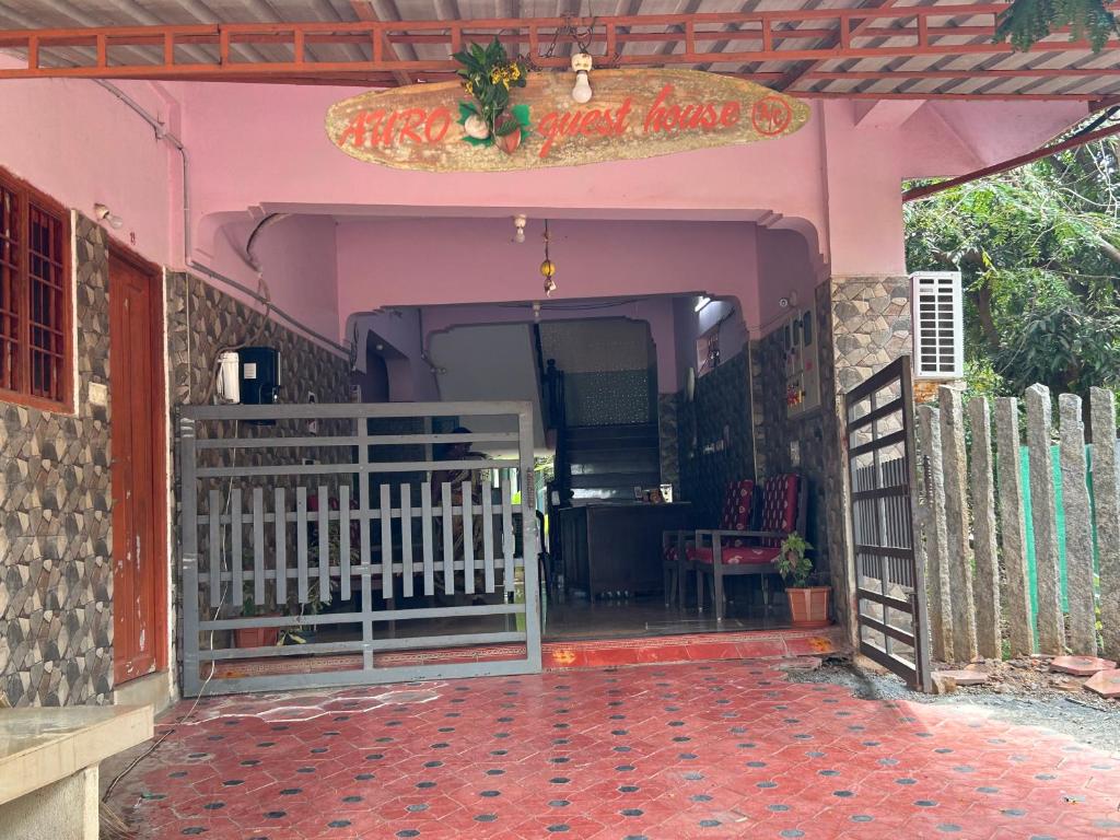 una entrada a una casa rosa con una puerta blanca en AURO GUEST HOUSE en Auroville
