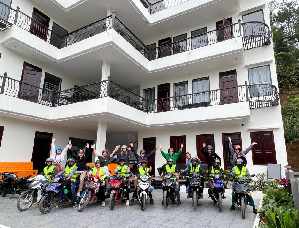 eine Gruppe von Personen auf Motorrädern vor einem Gebäude in der Unterkunft LiLa Inn & Motorbike Tours Ha Giang in Ha Giang