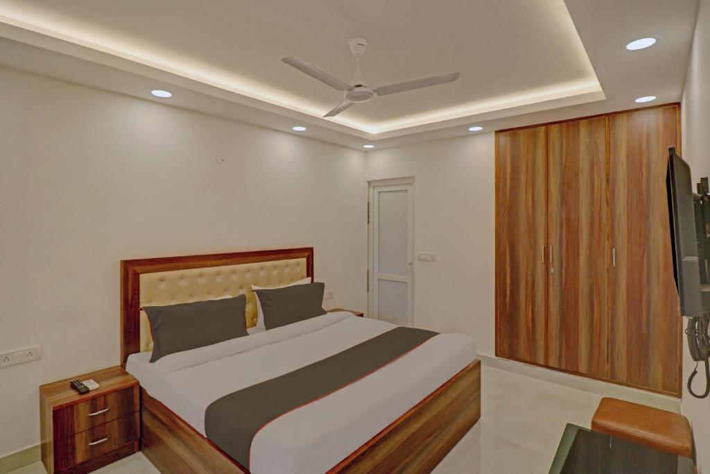 een slaapkamer met een bed en een plafondventilator bij Super Collection O Hotel Spot Light Near Tughlakabad Station Metro Station in Indraprastha