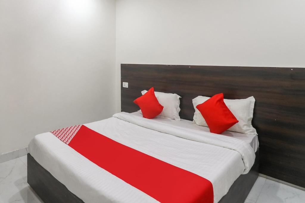 - une chambre avec un lit doté d'oreillers rouges et blancs dans l'établissement OYO Hotel Galaxy, à Faridabad