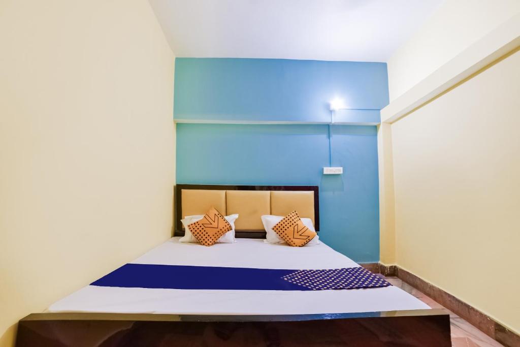 uma cama num quarto com uma parede azul em SPOT ON Luv-kush Inn em Bankipur