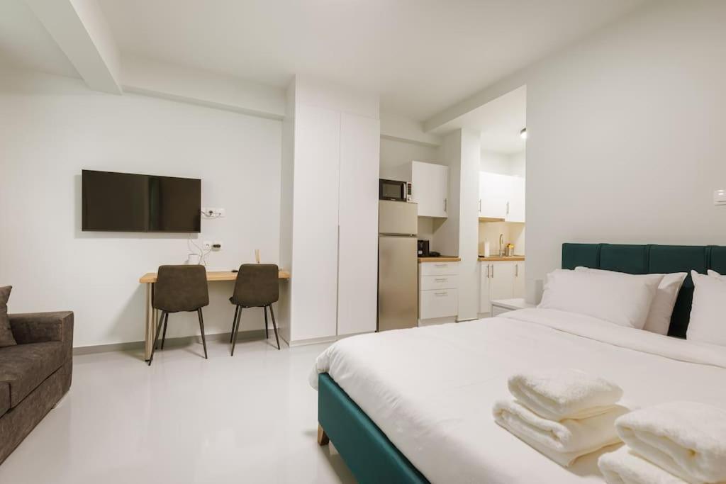 a bedroom with a bed and a couch and a kitchen at Snug studio apartment with pvt garden access III in Athens