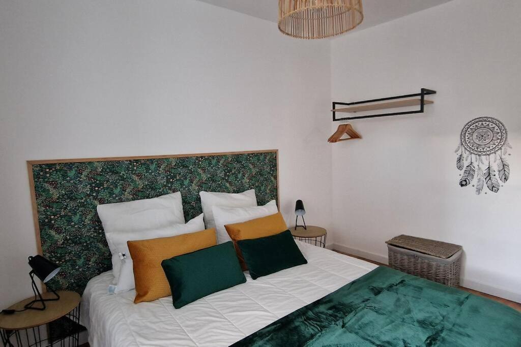 Schlafzimmer mit einem Bett mit grünen und orangefarbenen Kissen in der Unterkunft Gîte Garralda Pays Basque 6 pers in Saint-Esteben