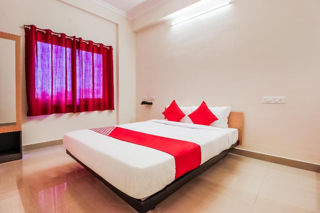 Schlafzimmer mit einem Bett und einem roten Fenster in der Unterkunft Flagship Neknampur Near Golconda Fort in Haidar Sāhibgūda