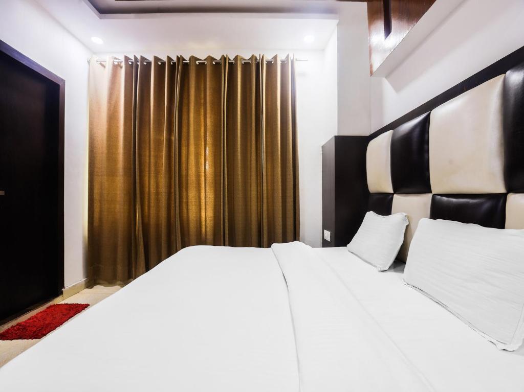 Un dormitorio con una gran cama blanca y una ventana en OYO Hotel Br Villa, en Nārnaul
