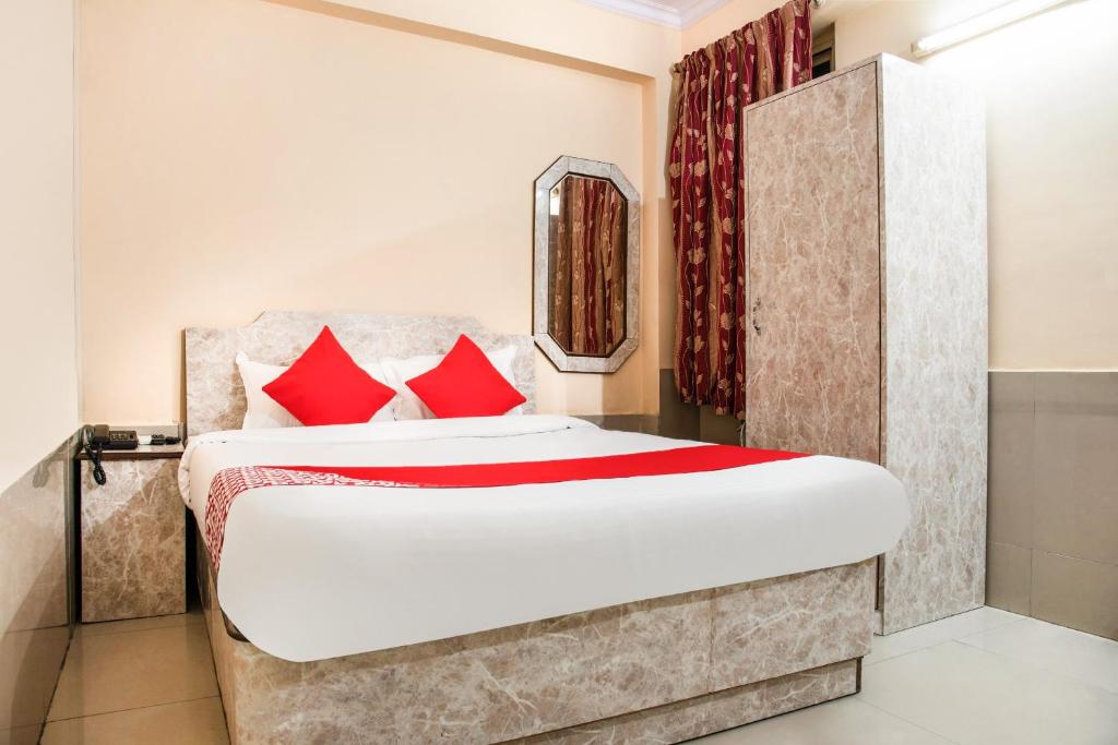 a bedroom with a large bed with red pillows at Flagship Hotel Embassy Exhibition Rd in Patna