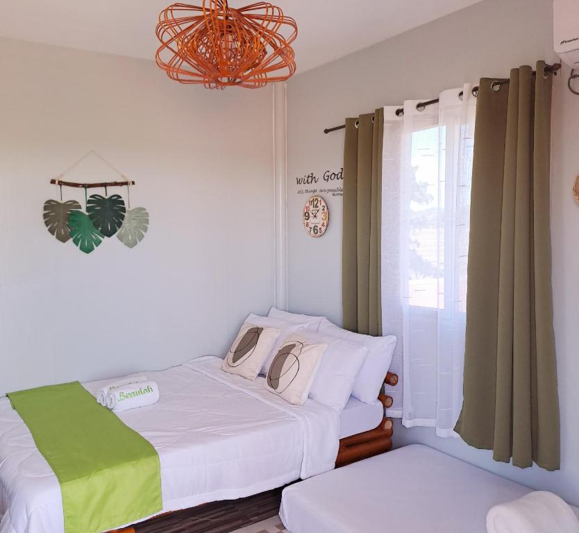 een slaapkamer met 2 bedden en een kroonluchter bij The Beaulah Overlooking Cozy Hideaway in Hundred Islands in Alaminos