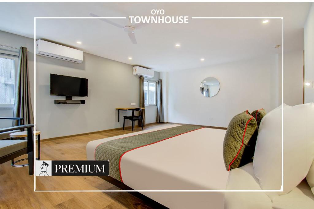 a hotel room with a bed and a tv at Townhouse 165 Netaji Road in Ahmedabad