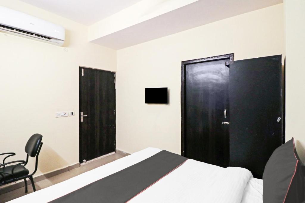 1 dormitorio con cama y puerta negra en Collection O Tara Patel, en Ghaziabad