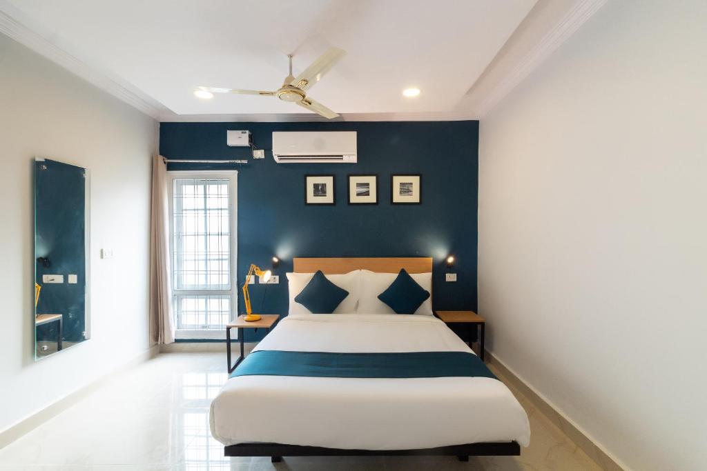 een slaapkamer met een groot bed en een blauwe muur bij Silverkey Himayat Nagar Circle Near Snow World in Hyderabad