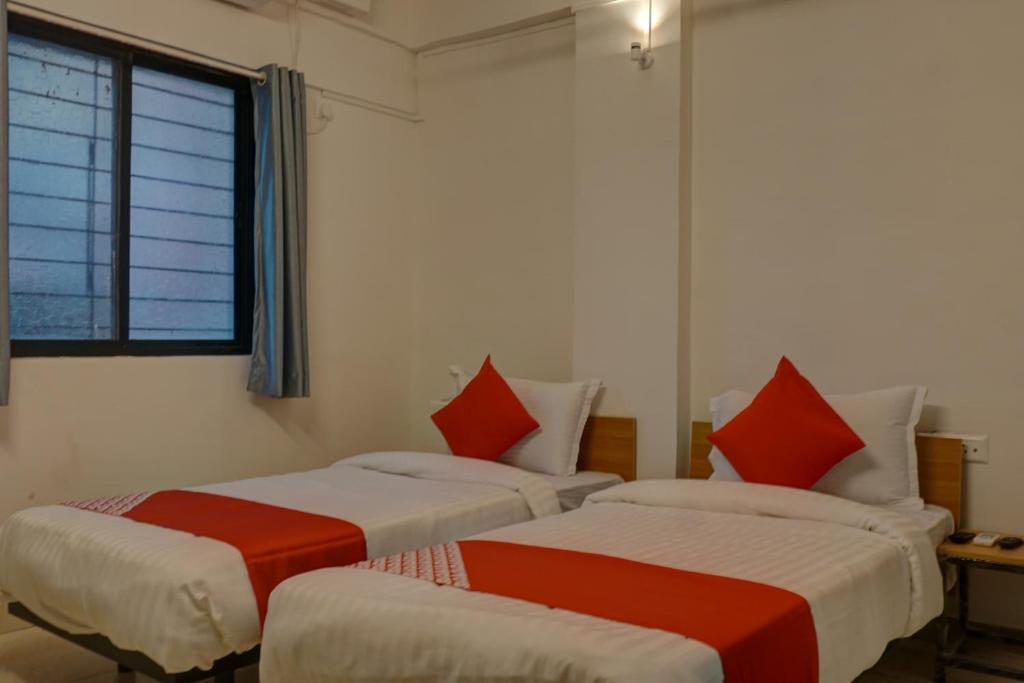 a room with two beds with red pillows at Flagship Sbk Icon Near Fun Time Multiplex in Māngvādi