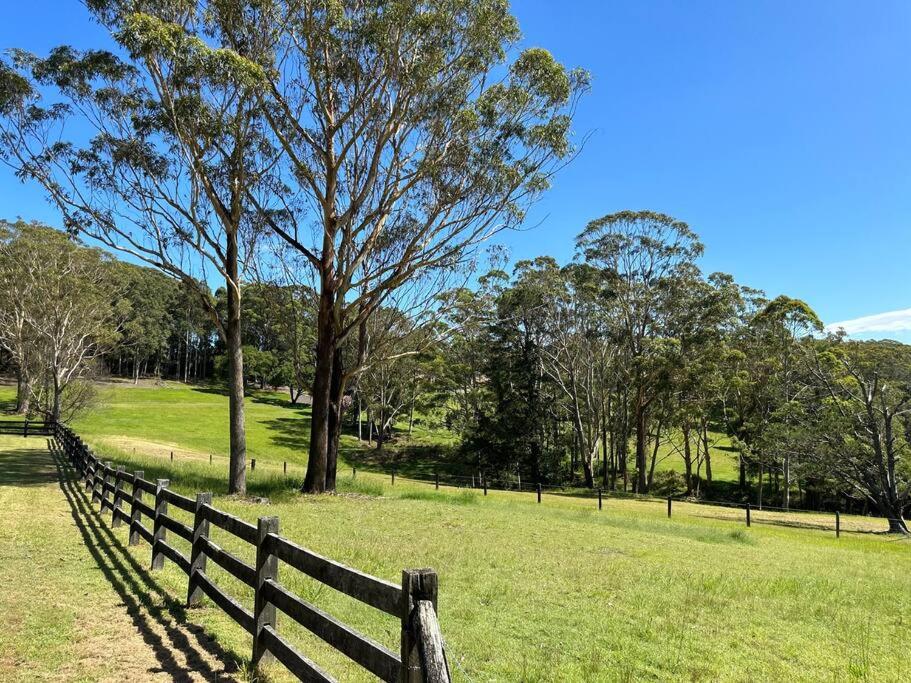 a wooden fence in a field with trees and grass at Aircabin｜KANGY ANGY｜Lovely｜4 Beds Holiday House in Tuggerah