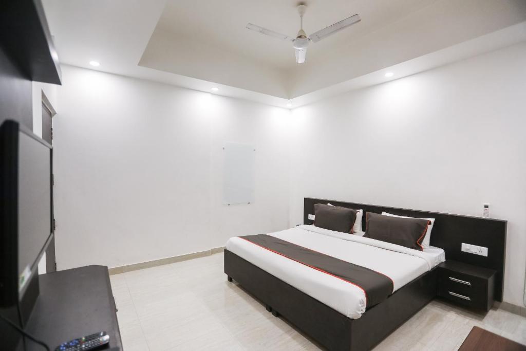 a bedroom with a bed and a television in it at Collection O Hotel Belmorrise in Noida