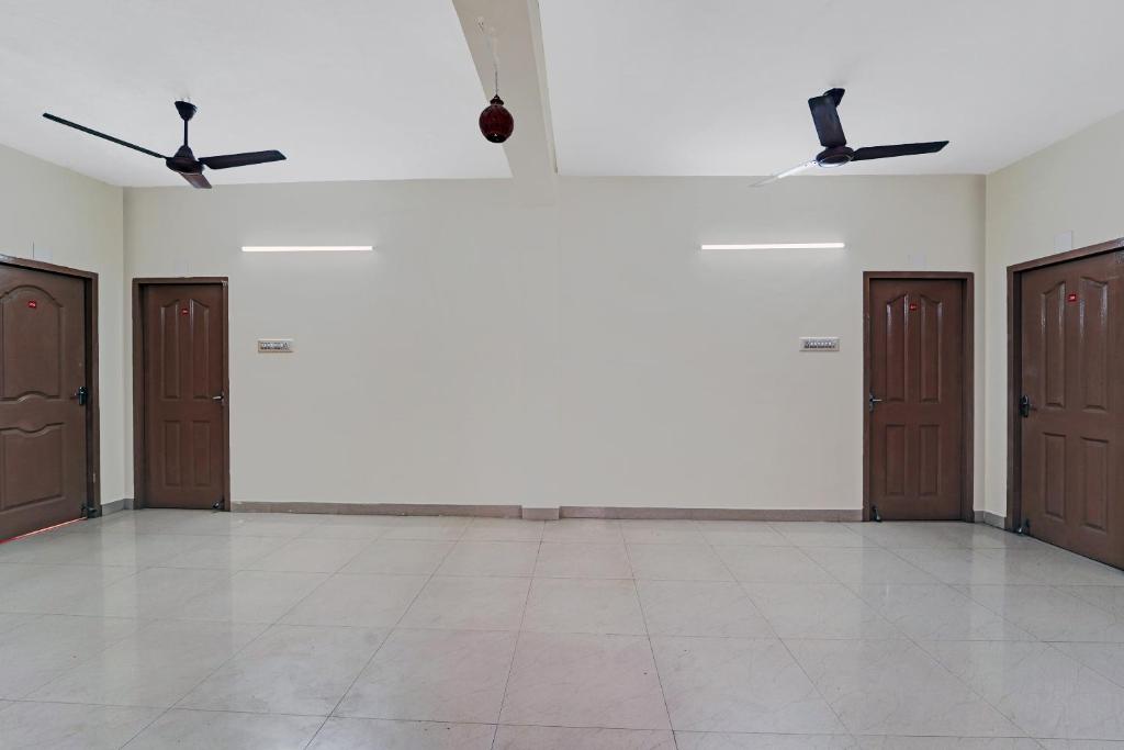 an empty room with brown doors and a tiled floor at Collection O Senthamizh Residency in Chennai